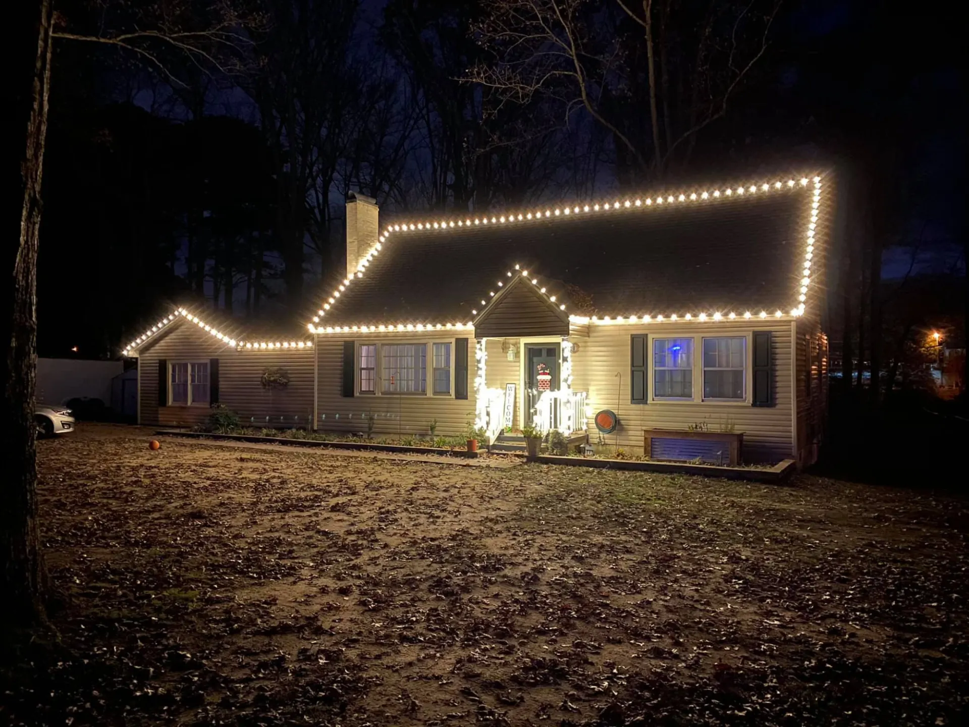 A house outlined in warm white Christmas lights installed by HRH Lawn Care